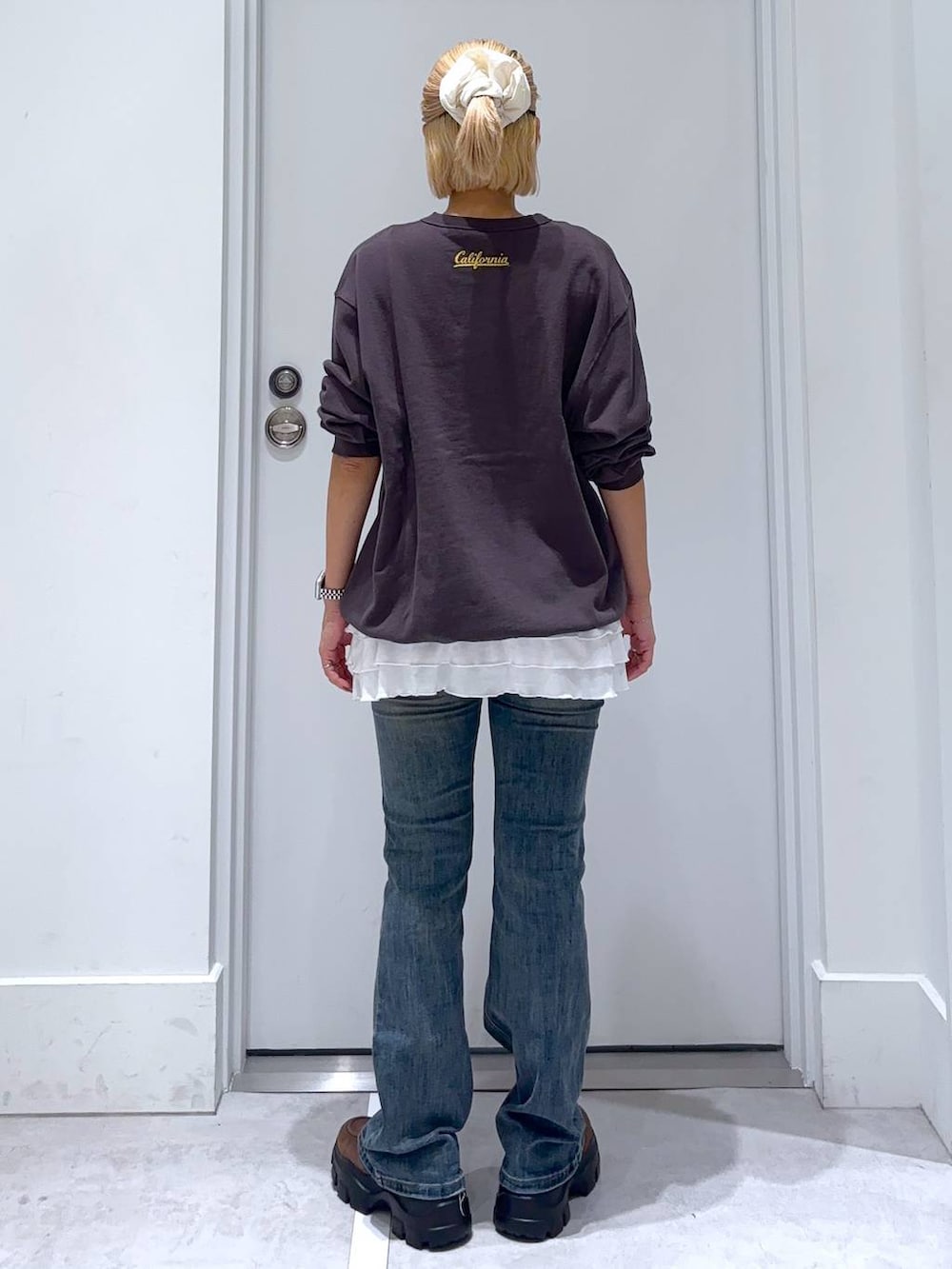 ブルー系のデニムパンツ、グレー系のスウェット、ブラウン系のモカシン/デッキシューズを着用したレディースの秋コーディネートの6枚目の写真