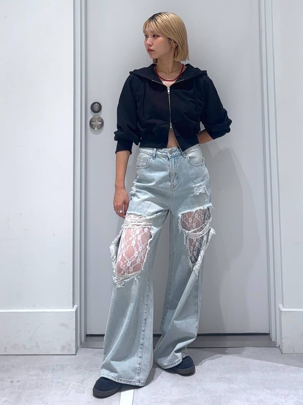 ブラック系のパーカー、ブルー系のデニムパンツを着用したレディースの秋コーディネートの3枚目の写真