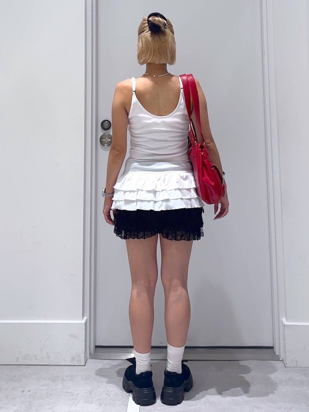 ブラック系のその他パンツ、ブラック系のモカシン/デッキシューズ、レッド系のショルダーバッグを着用したレディースの夏コーディネートの4枚目の写真