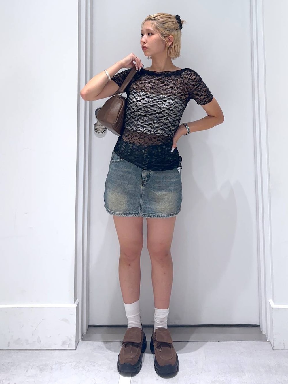 ブラック系のTシャツ/カットソー、ブラウン系のモカシン/デッキシューズ、ブルー系のデニムスカートを着用したレディースの夏コーディネートの2枚目の写真