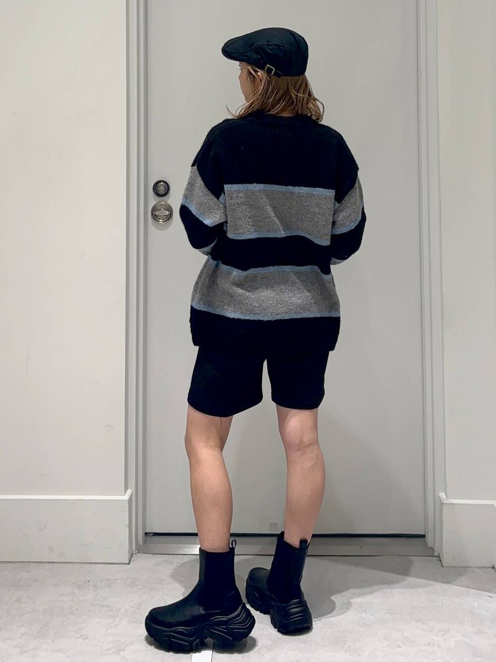 ブラック系のスラックス、ブラック系のブーツ、ブラック系のニット/セーターを着用したレディースの冬コーディネートの4枚目の写真