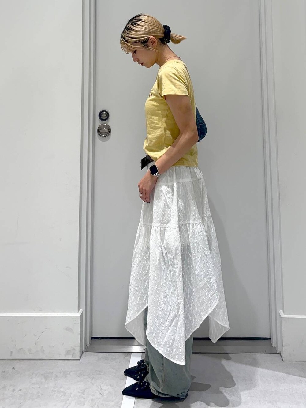 ブルー系のデニムパンツ、ブルー系のショルダーバッグ、レッド系のパンプスを着用したレディースの春コーディネートの4枚目の写真
