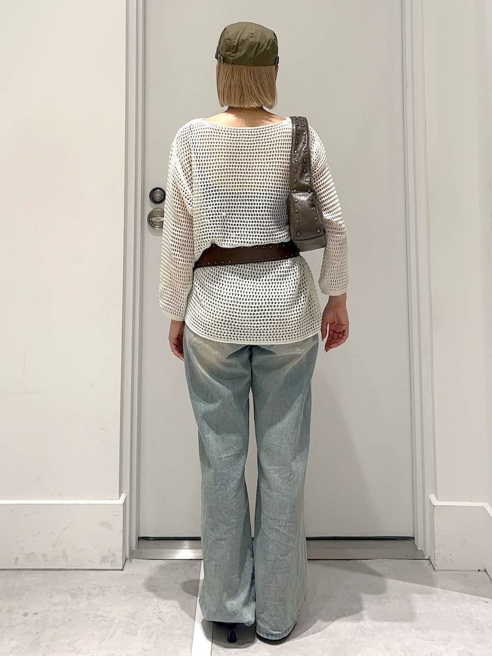 ブルー系のデニムパンツ、ブラウン系のその他シューズ、ブラウン系のハンドバッグを着用したレディースの春コーディネートの4枚目の写真