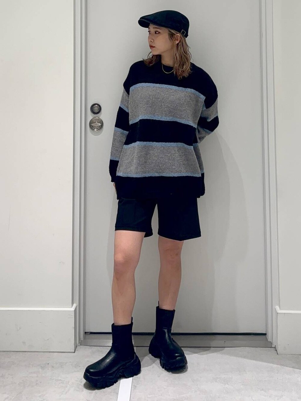 ブラック系のスラックス、ブラック系のブーツ、ブラック系のニット/セーターを着用したレディースの冬コーディネートの2枚目の写真