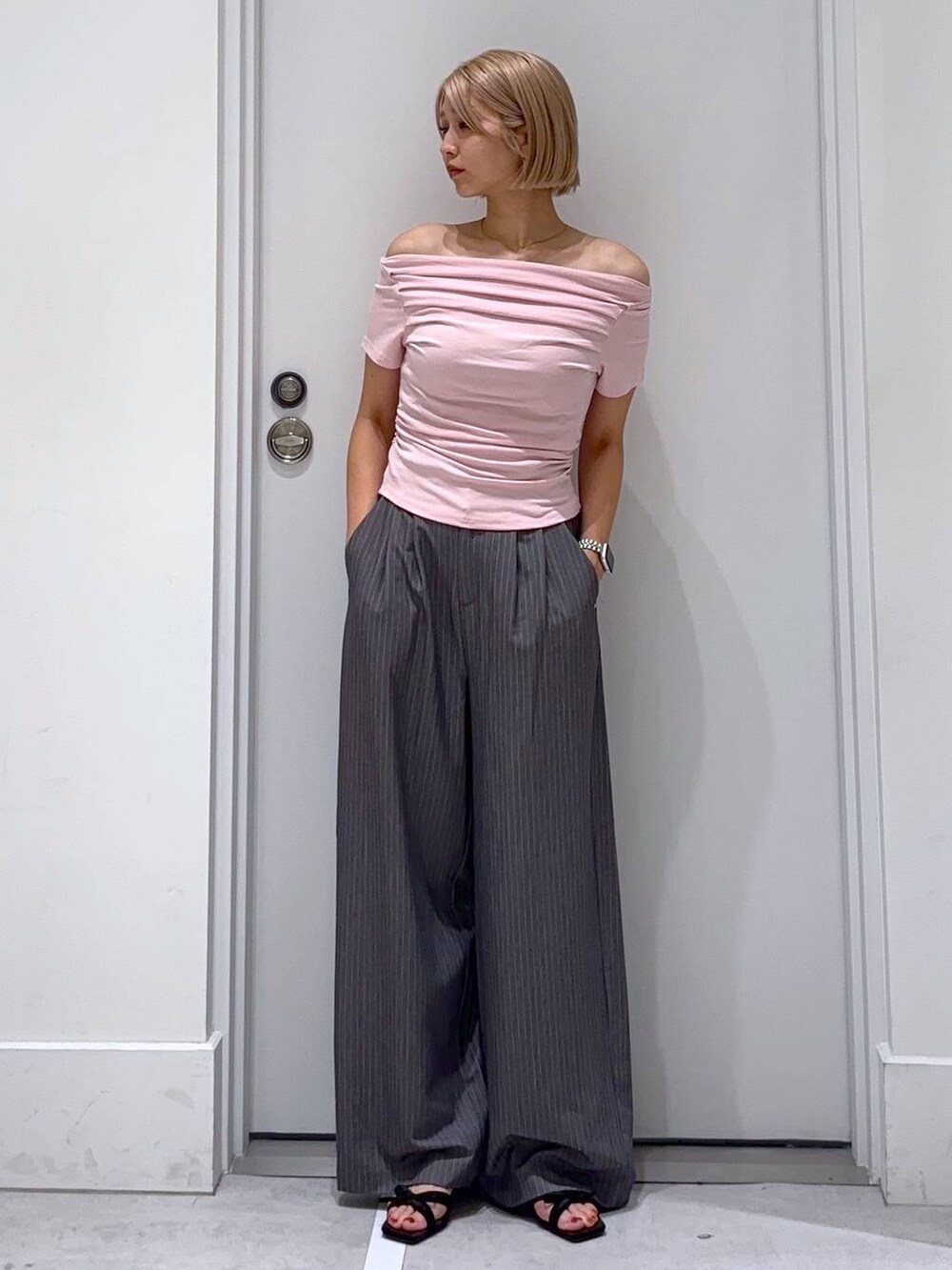 ブラック系のサンダル、グレー系のスラックスを着用したレディースの夏コーディネートの3枚目の写真