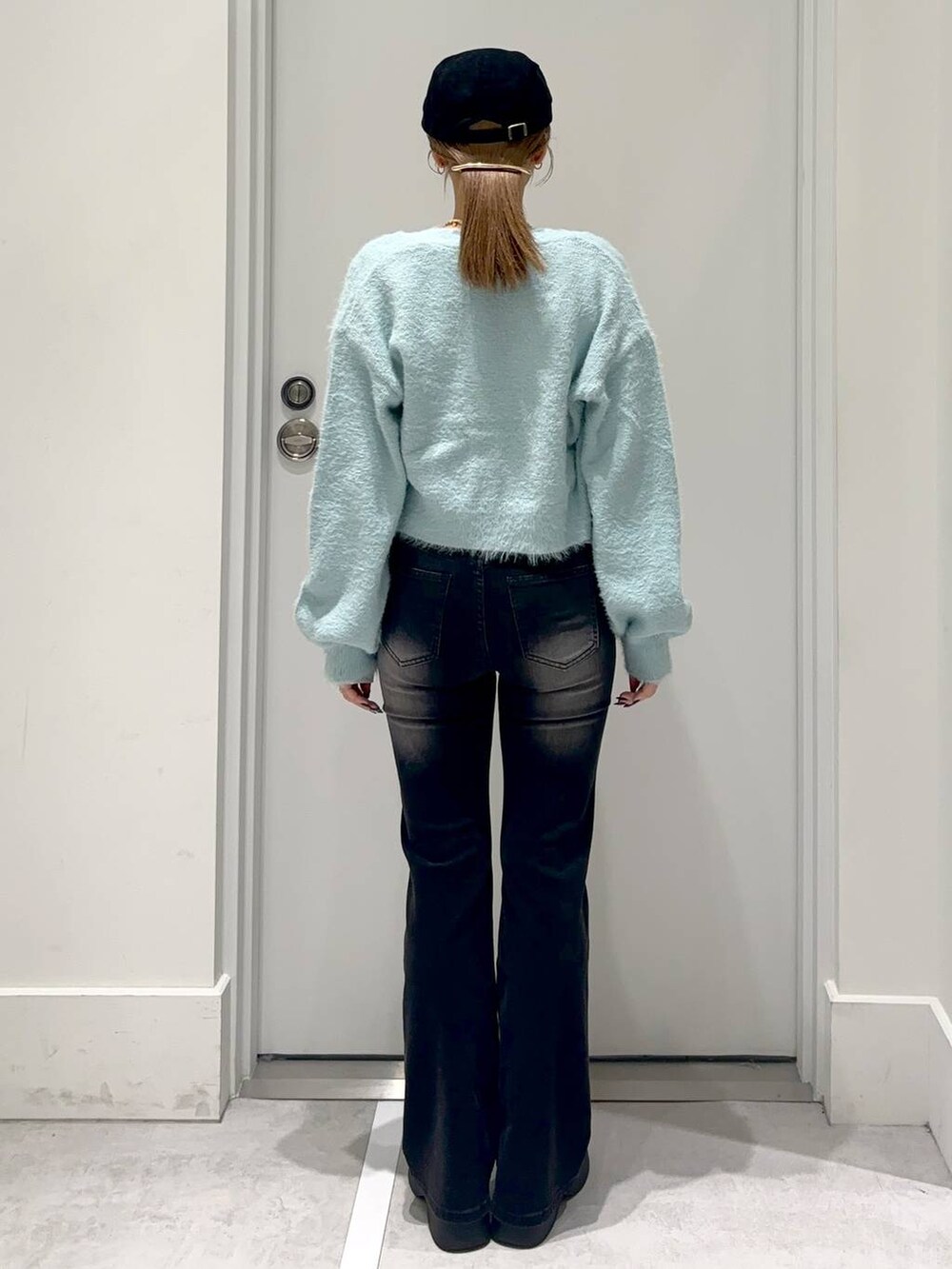 ブルー系のカーディガン/ボレロ、ブラック系のスリッポン、ブラック系のデニムパンツを着用したレディースの冬コーディネートの5枚目の写真