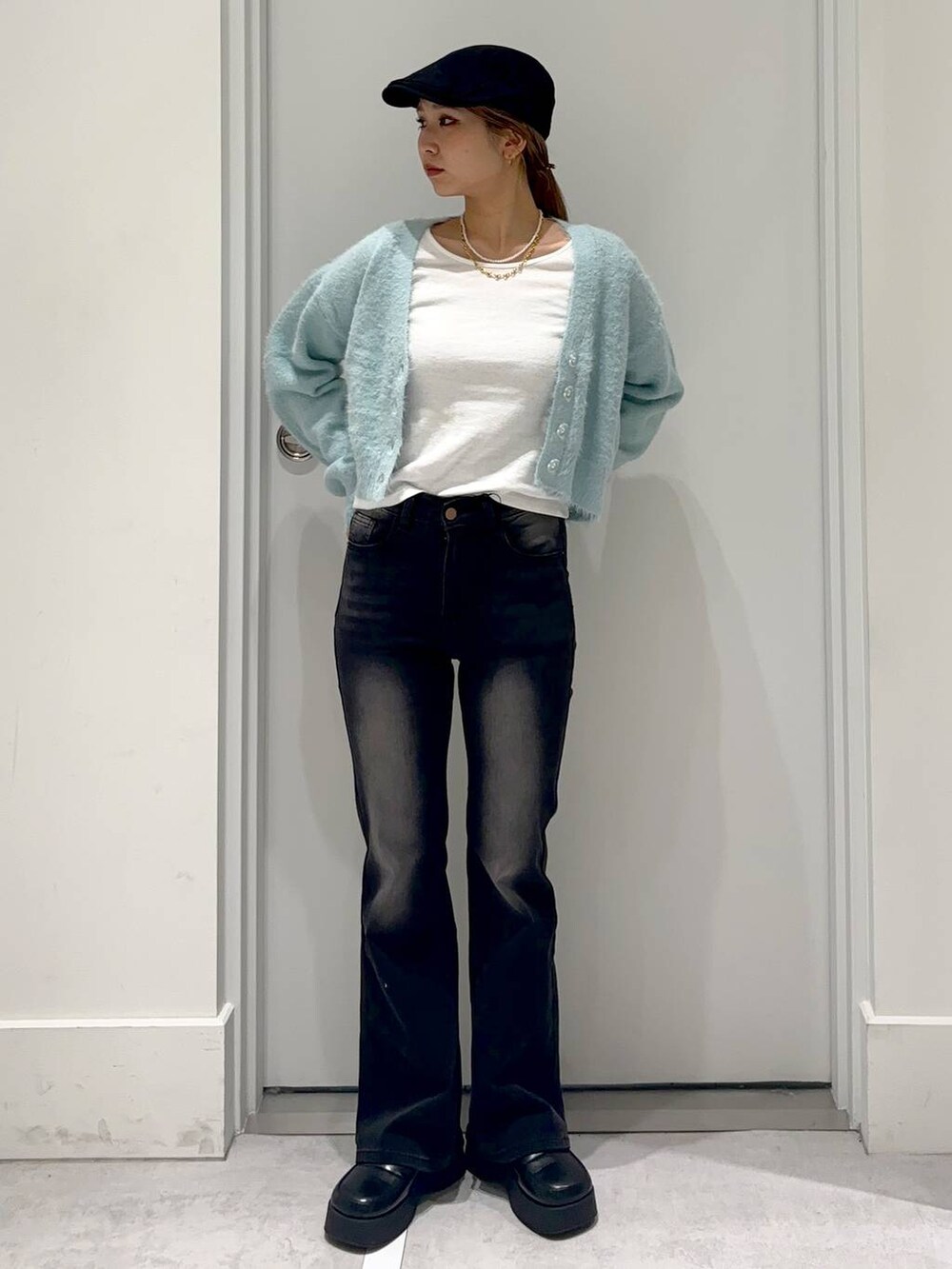 ブルー系のカーディガン/ボレロ、ブラック系のスリッポン、ブラック系のデニムパンツを着用したレディースの冬コーディネートの2枚目の写真