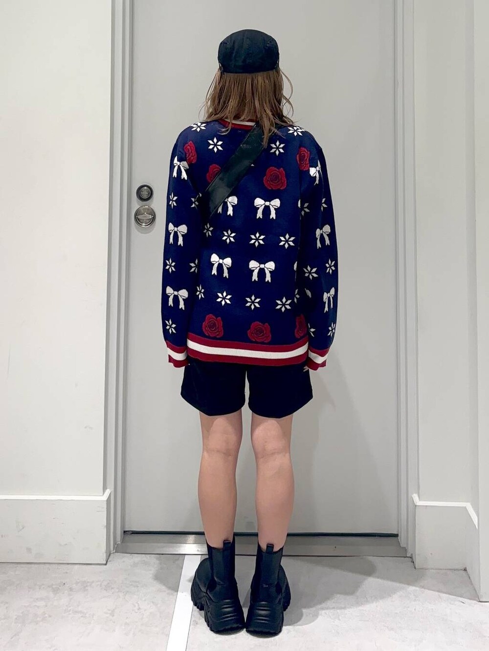 ブラック系のショルダーバッグ、ブラック系のスラックス、ブラック系のブーツを着用したレディースの冬コーディネートの4枚目の写真