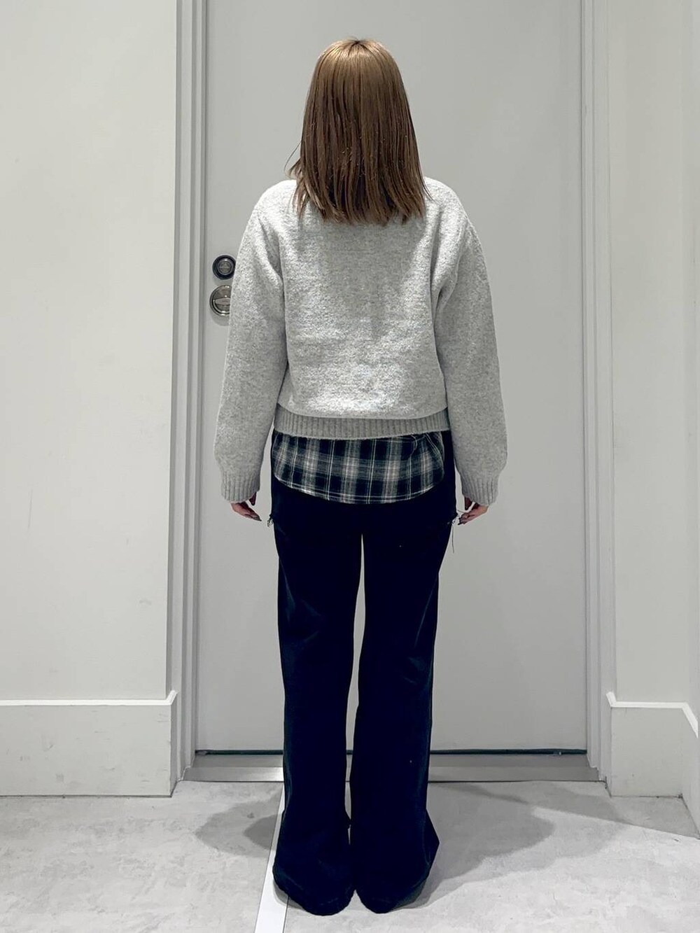 ブラック系のシャツ/ブラウス、グレー系のデニムパンツ、グレー系のニット/セーターを着用したレディースの冬コーディネートの4枚目の写真