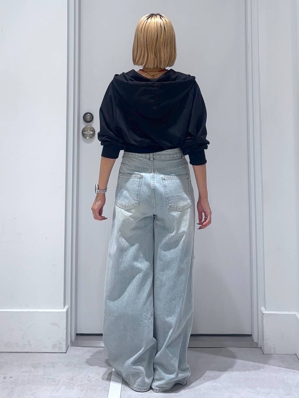 ブラック系のパーカー、ブルー系のデニムパンツを着用したレディースの秋コーディネートの5枚目の写真