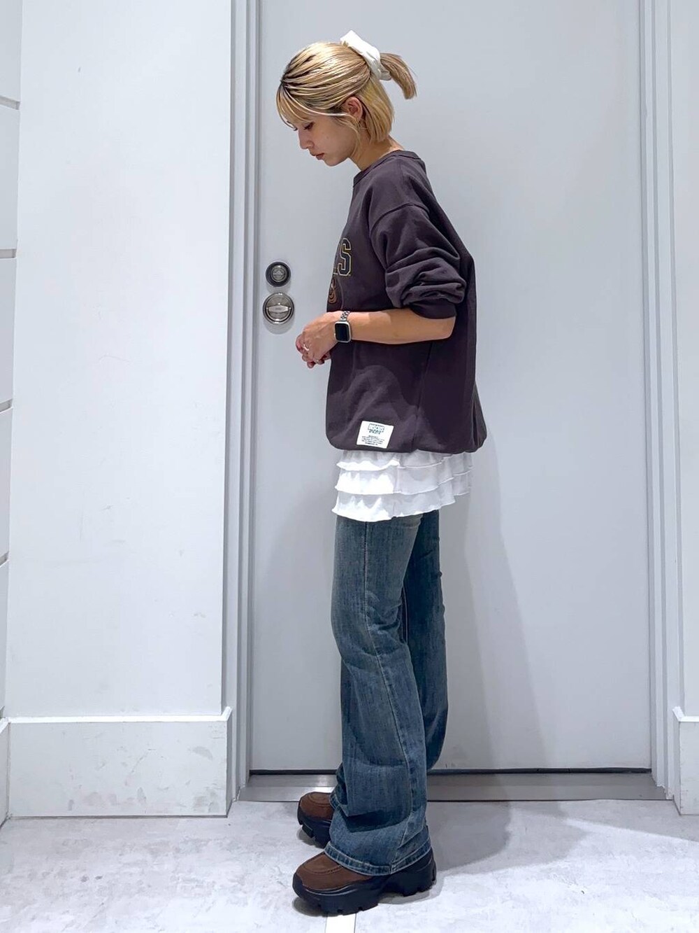 ブルー系のデニムパンツ、グレー系のスウェット、ブラウン系のモカシン/デッキシューズを着用したレディースの秋コーディネートの5枚目の写真