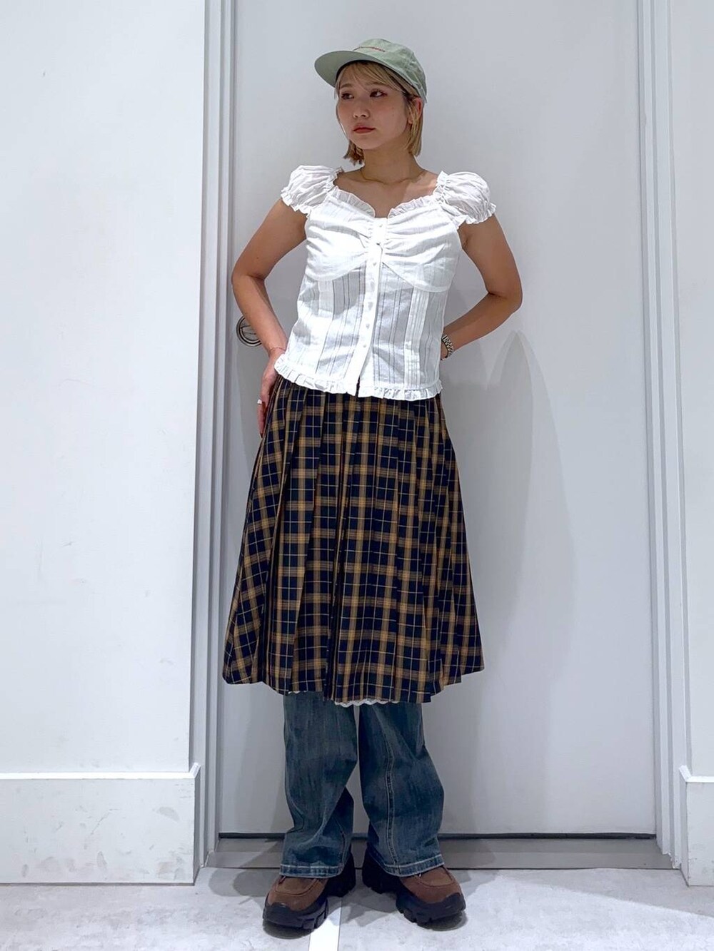 ブルー系のデニムパンツ、ブルー系のスカート、ブラウン系のモカシン/デッキシューズを着用したレディースの秋コーディネートの3枚目の写真