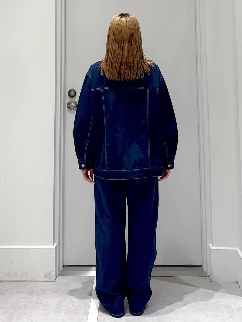 ブルー系のデニムパンツ、ゴールド系のネックレスを着用したレディースの冬コーディネートの5枚目の写真