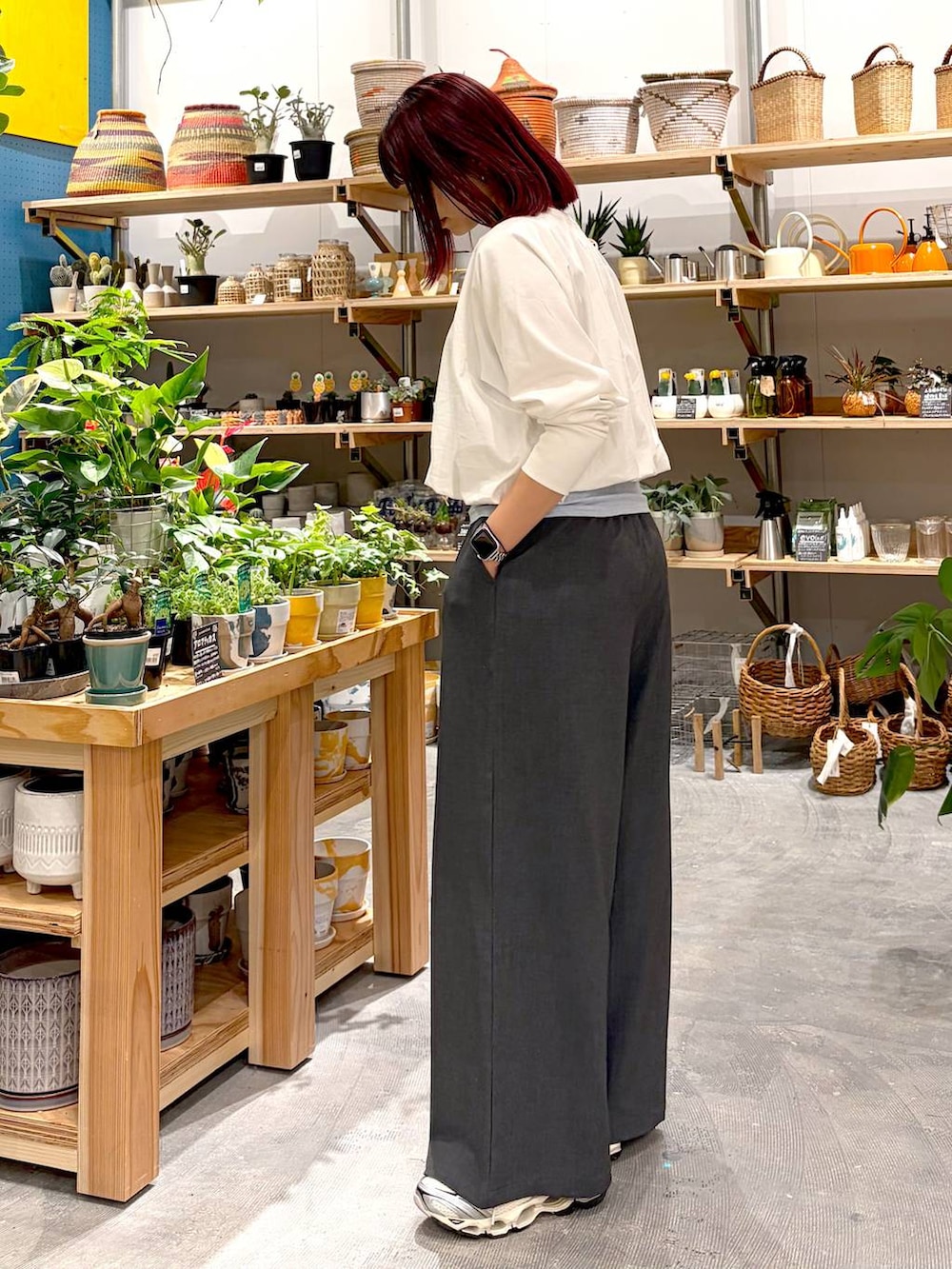 グレー系のその他パンツ、ブラック系のハンドバッグ、ブルー系のタンクトップを着用したレディースの春コーディネートの2枚目の写真