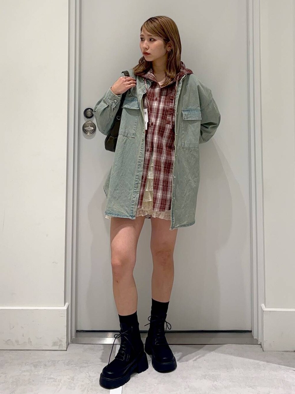 ベージュ系のその他パンツ、ブルー系のシャツ/ブラウス、ブラック系のブーツを着用したレディースの春コーディネートの3枚目の写真