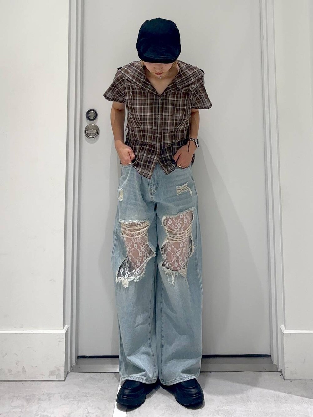 ブラウン系のシャツ/ブラウス、ブルー系のデニムパンツ、ブラック系のハンチング/ベレー帽を着用したレディースの春コーディネートの2枚目の写真
