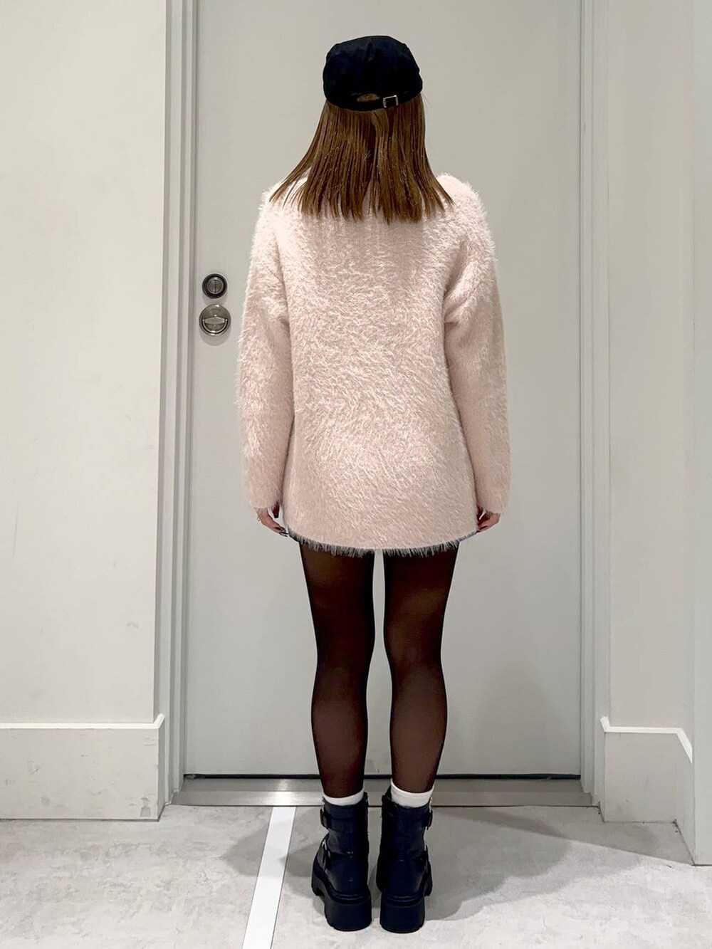 ブラック系のスカート、ピンク系のチュニック、ブラック系のハンチング/ベレー帽を着用したレディースの冬コーディネートの4枚目の写真