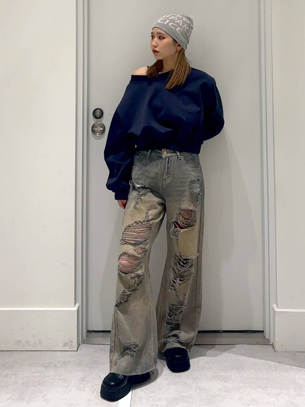 ブラック系のスリッポン、ブルー系のスウェット、ブルー系のデニムパンツを着用したレディースの冬コーディネートの2枚目の写真