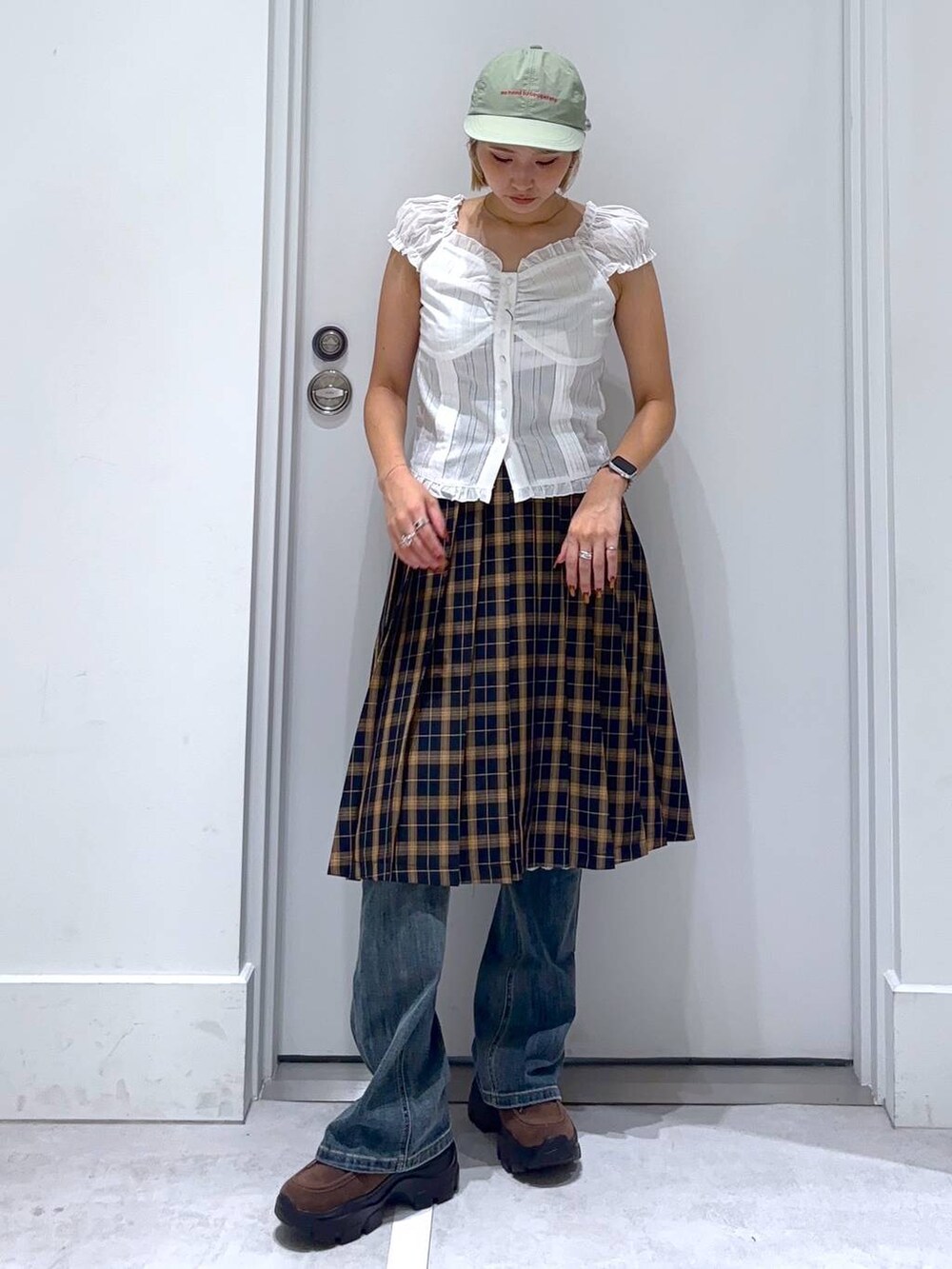 ブルー系のデニムパンツ、ブルー系のスカート、ブラウン系のモカシン/デッキシューズを着用したレディースの秋コーディネートの4枚目の写真