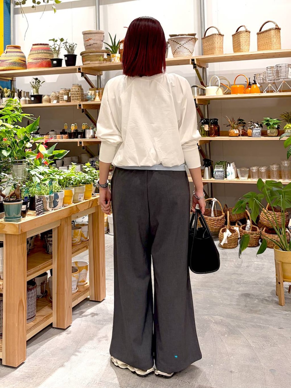 グレー系のその他パンツ、ブラック系のハンドバッグ、ブルー系のタンクトップを着用したレディースの春コーディネートの3枚目の写真