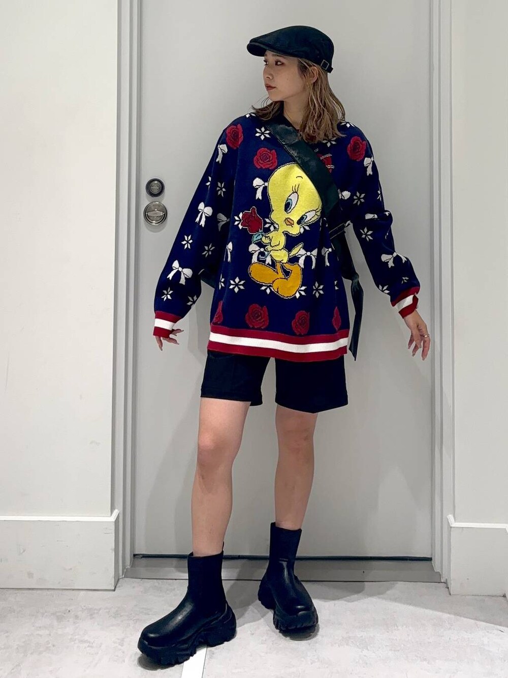 ブラック系のショルダーバッグ、ブラック系のスラックス、ブラック系のブーツを着用したレディースの冬コーディネートの2枚目の写真