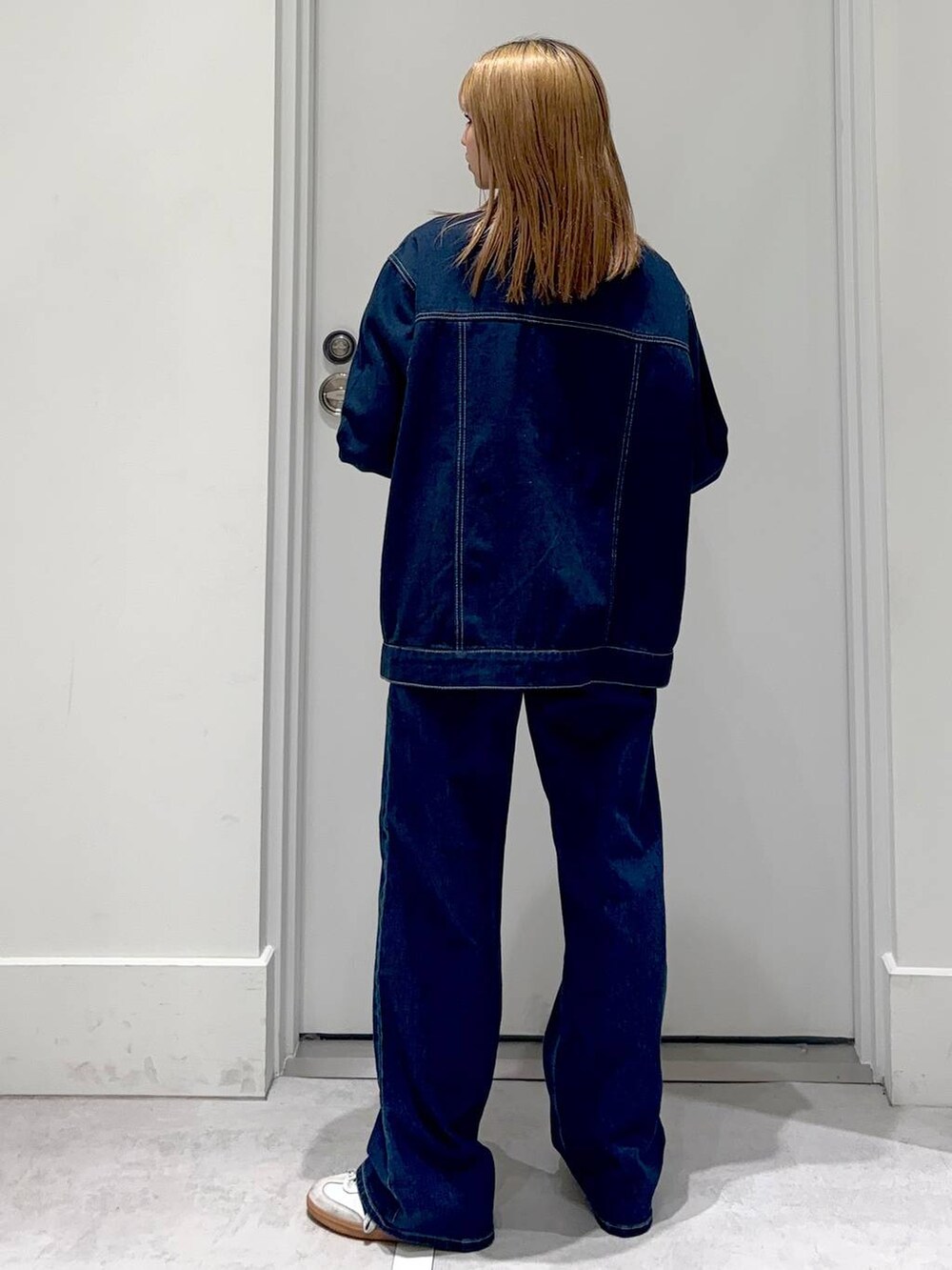 ブルー系のデニムパンツ、ゴールド系のネックレスを着用したレディースの冬コーディネートの4枚目の写真