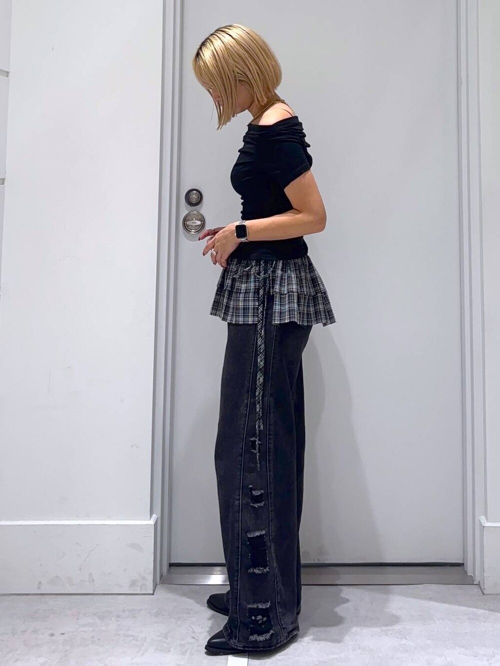 ブラック系のデニムパンツ、ブラック系のTシャツ/カットソー、ブラック系のベルトを着用したレディースの秋コーディネートの3枚目の写真
