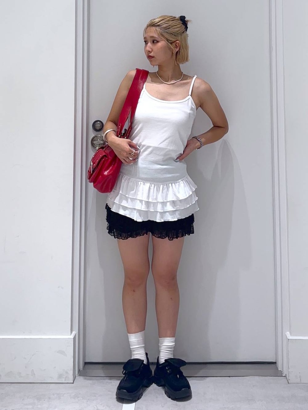 ブラック系のその他パンツ、ブラック系のモカシン/デッキシューズ、レッド系のショルダーバッグを着用したレディースの夏コーディネートの2枚目の写真