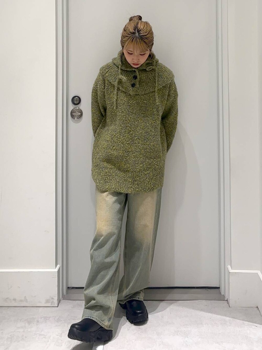 ブルー系のデニムパンツ、グリーン系のニット/セーターを着用したレディースの冬コーディネートの2枚目の写真