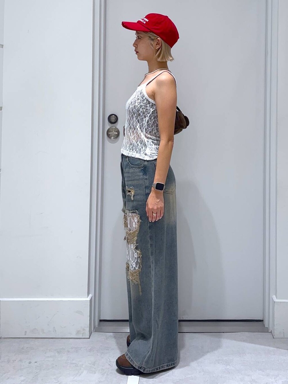 ブラウン系のキャミソール、ブルー系のデニムパンツ、ブラウン系のモカシン/デッキシューズを着用したレディースの夏コーディネートの4枚目の写真