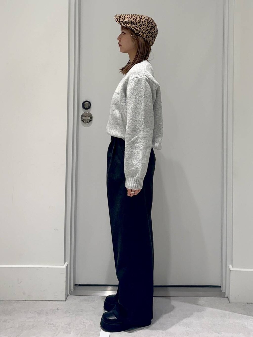 ブラック系のスリッポン、グレー系のスラックス、グレー系のニット/セーターを着用したレディースの冬コーディネートの3枚目の写真