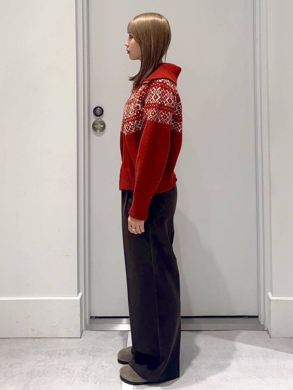 ブラウン系のスラックス、レッド系のニット/セーターを着用したレディースの冬コーディネートの3枚目の写真