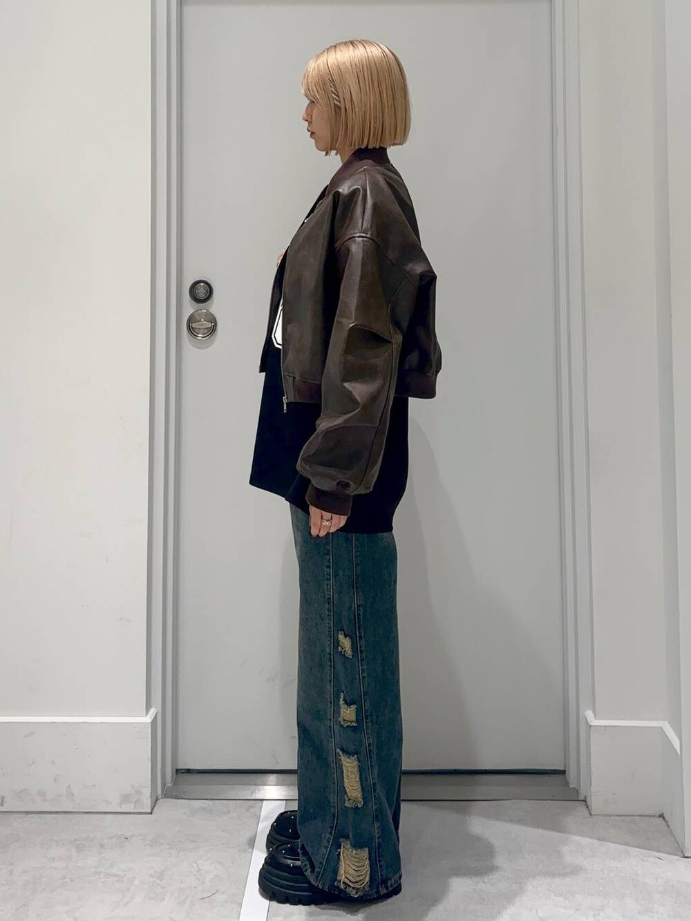 ブラウン系のMA-1、ブラック系のデニムパンツ、ブラック系のローファーを着用したレディースの春コーディネートの2枚目の写真