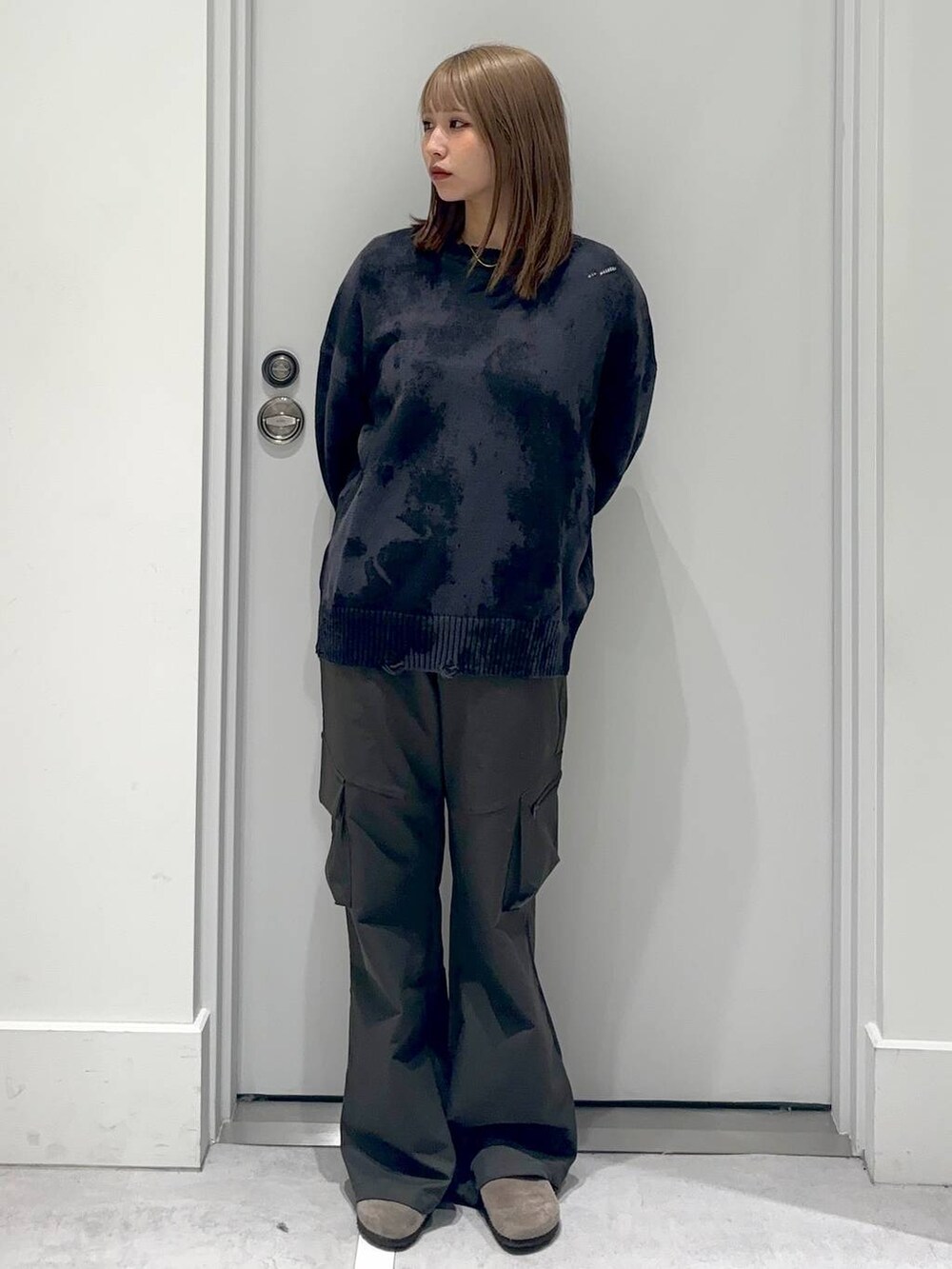 グリーン系のカーゴパンツ、グレー系のニット/セーターを着用したレディースの冬コーディネートの2枚目の写真