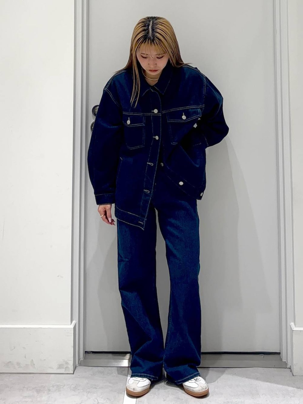 ブルー系のデニムパンツ、ゴールド系のネックレスを着用したレディースの冬コーディネートの2枚目の写真