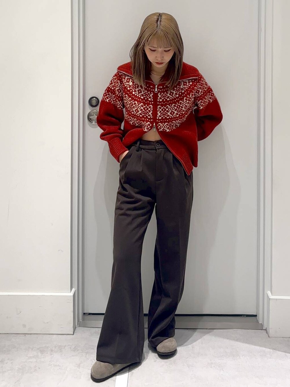 ブラウン系のスラックス、レッド系のニット/セーターを着用したレディースの冬コーディネートの2枚目の写真