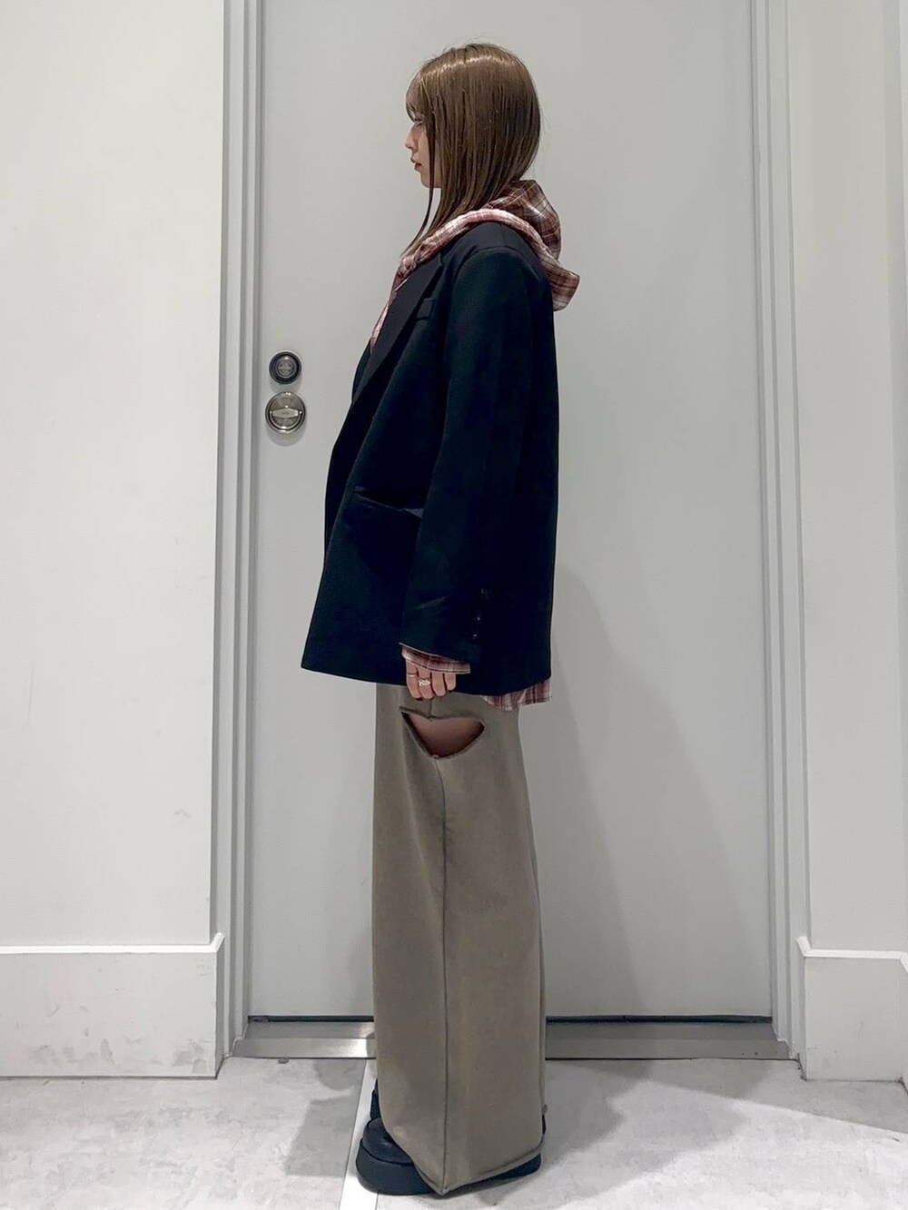 ブラック系のスリッポン、グリーン系のスウェットパンツ、ブラック系のテーラードジャケットを着用したレディースの冬コーディネートの3枚目の写真