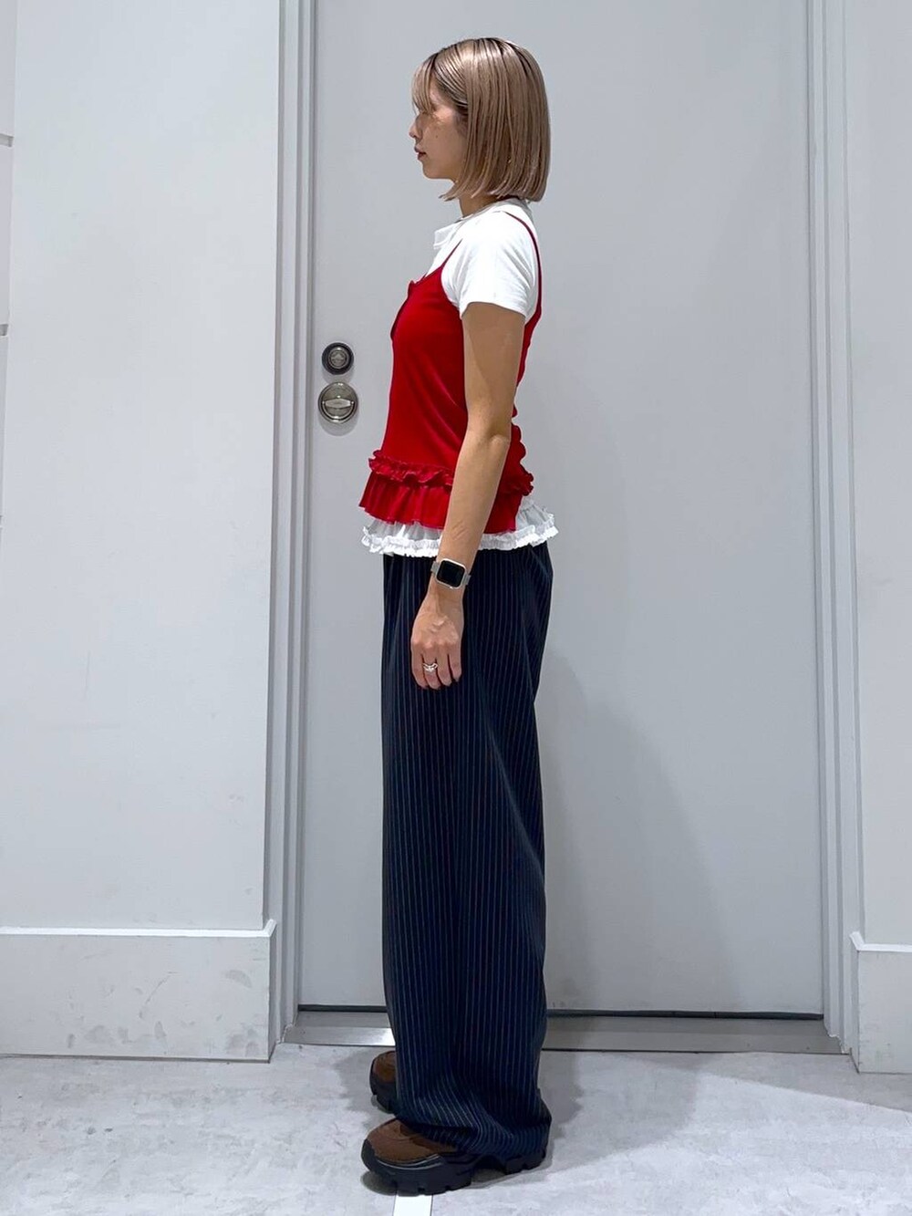 ブラウン系のモカシン/デッキシューズ、ブルー系のスラックス、ホワイト系のTシャツ/カットソーを着用したレディースの夏コーディネートの4枚目の写真