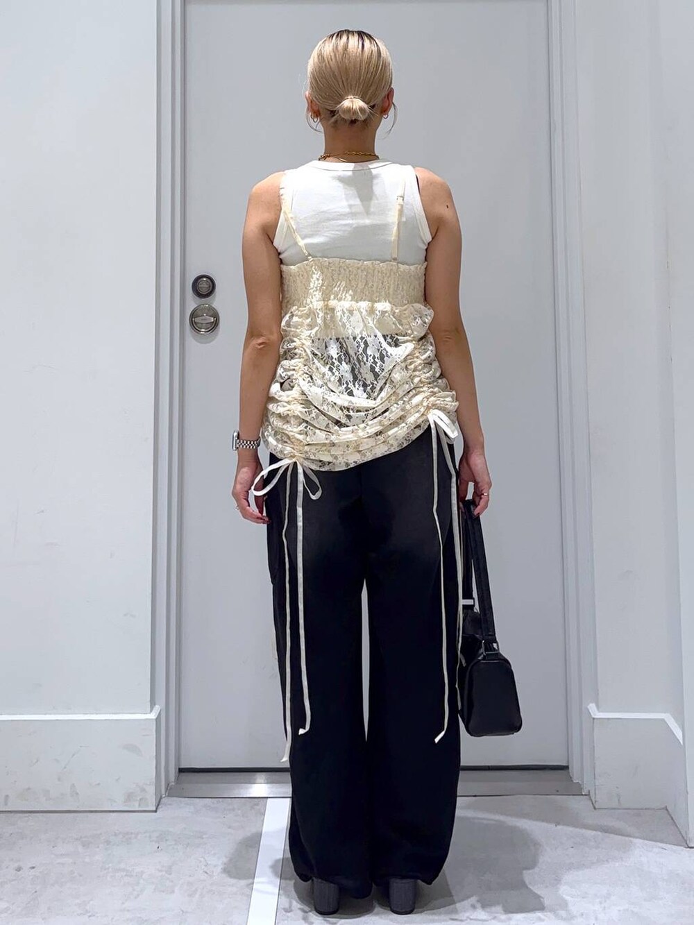 ベージュ系のワンピース、ホワイト系のタンクトップ、その他のサンダルを着用したレディースの夏コーディネートの5枚目の写真