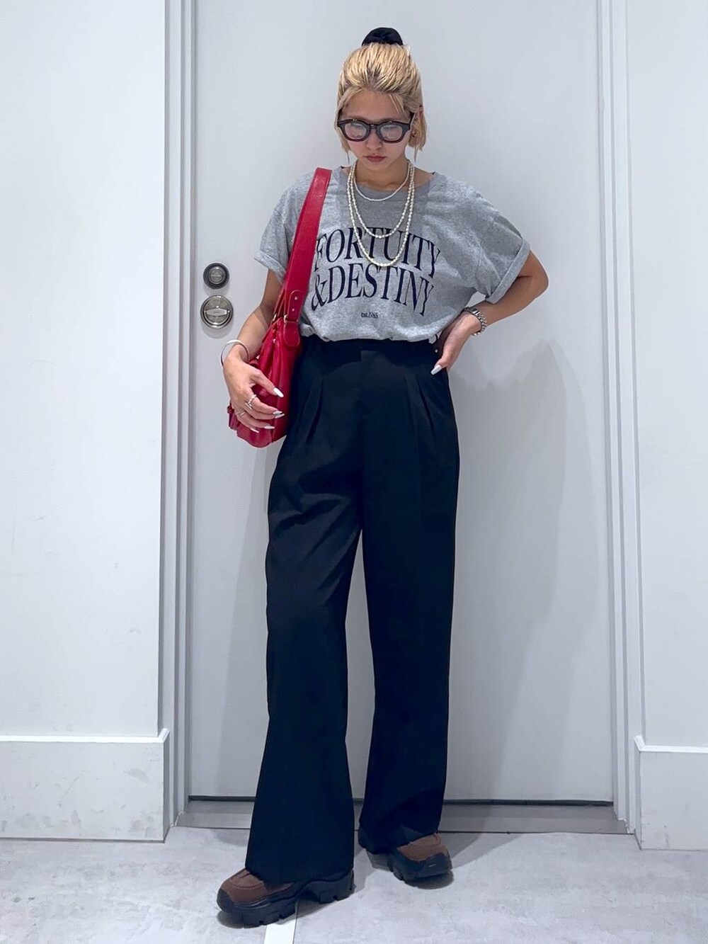 ブラウン系のモカシン/デッキシューズ、グレー系のTシャツ/カットソー、ブラック系のスラックスを着用したレディースの夏コーディネートの3枚目の写真