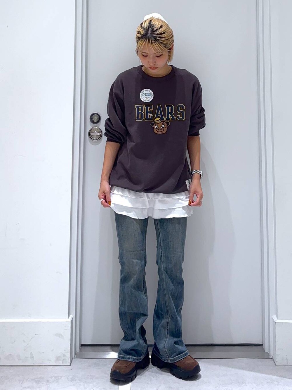 ブルー系のデニムパンツ、グレー系のスウェット、ブラウン系のモカシン/デッキシューズを着用したレディースの秋コーディネートの2枚目の写真