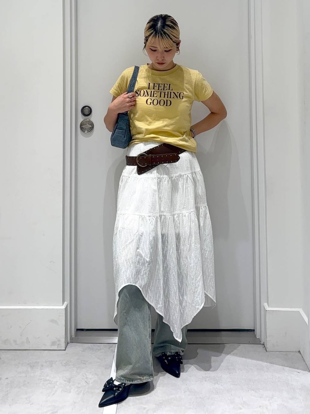 ブルー系のデニムパンツ、ブルー系のショルダーバッグ、レッド系のパンプスを着用したレディースの春コーディネートの2枚目の写真