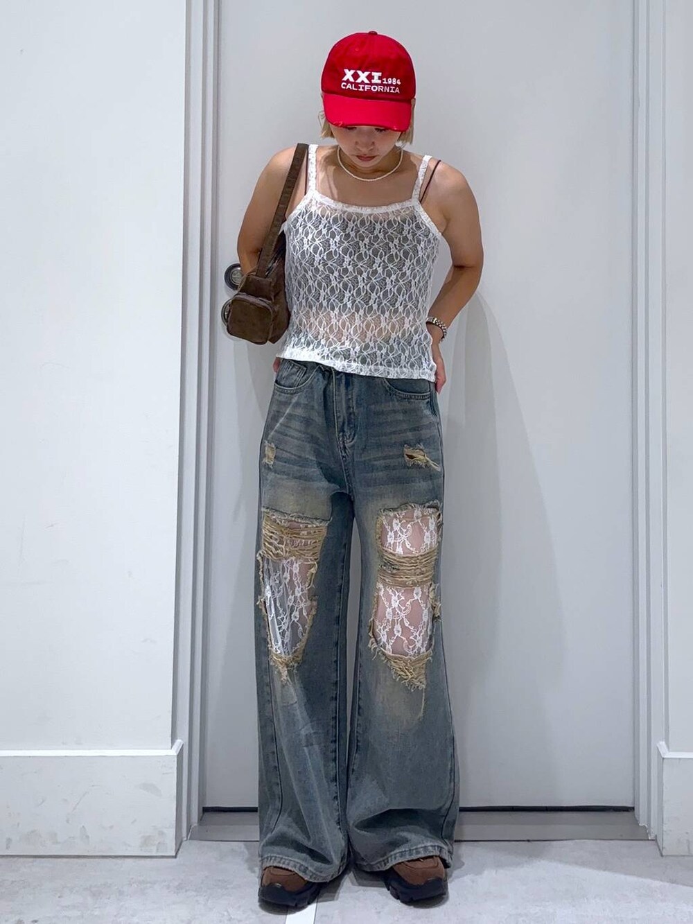 ブラウン系のキャミソール、ブルー系のデニムパンツ、ブラウン系のモカシン/デッキシューズを着用したレディースの夏コーディネートの2枚目の写真