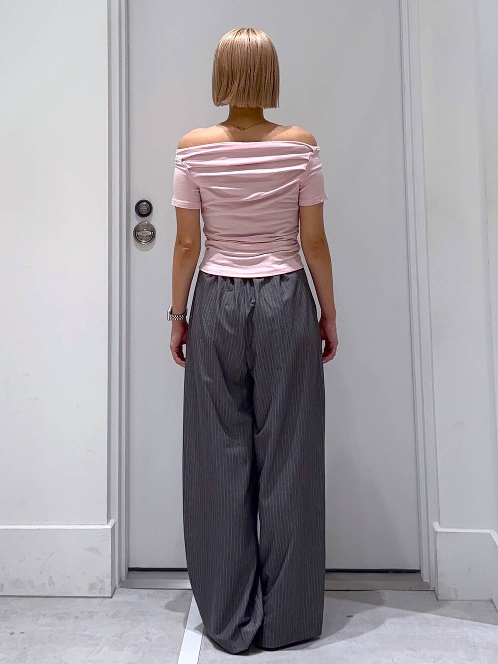 ブラック系のサンダル、グレー系のスラックスを着用したレディースの夏コーディネートの5枚目の写真