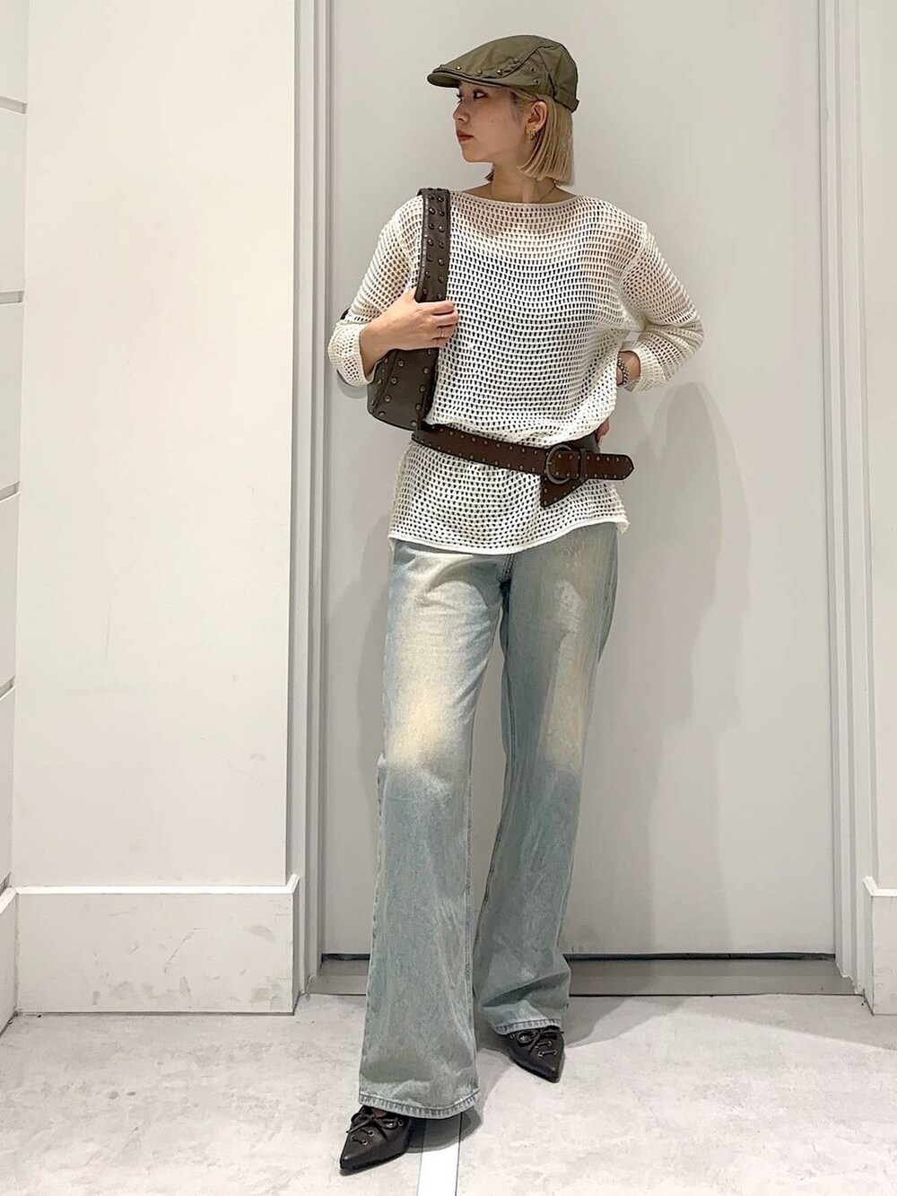 ブルー系のデニムパンツ、ブラウン系のその他シューズ、ブラウン系のハンドバッグを着用したレディースの春コーディネートの2枚目の写真