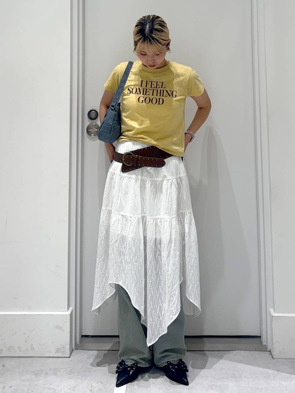 ブルー系のデニムパンツ、ブルー系のショルダーバッグ、レッド系のパンプスを着用したレディースの春コーディネートの3枚目の写真