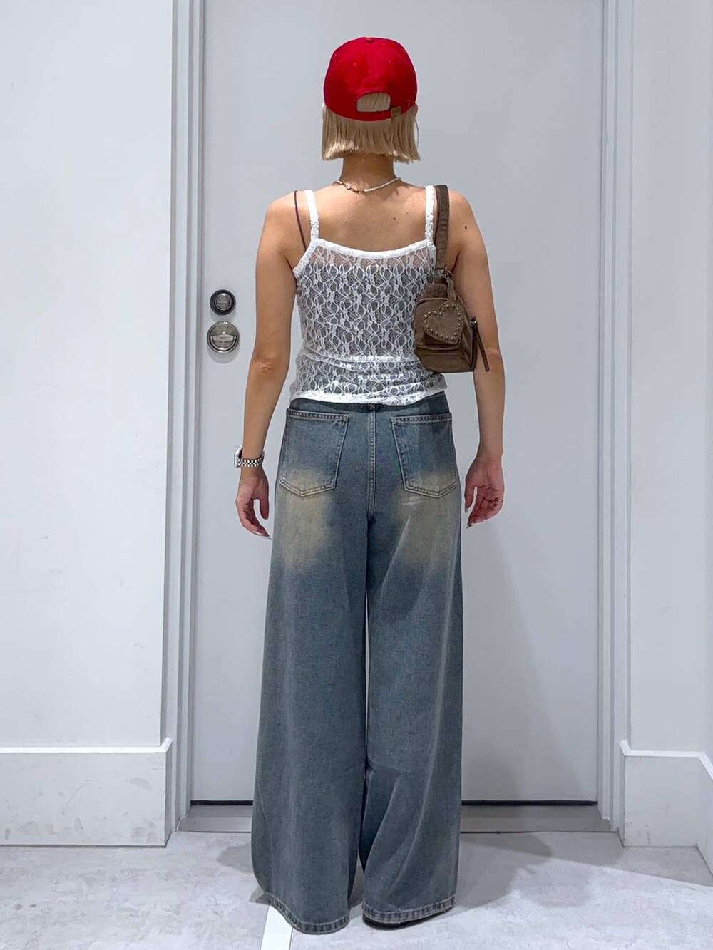 ブラウン系のキャミソール、ブルー系のデニムパンツ、ブラウン系のモカシン/デッキシューズを着用したレディースの夏コーディネートの5枚目の写真