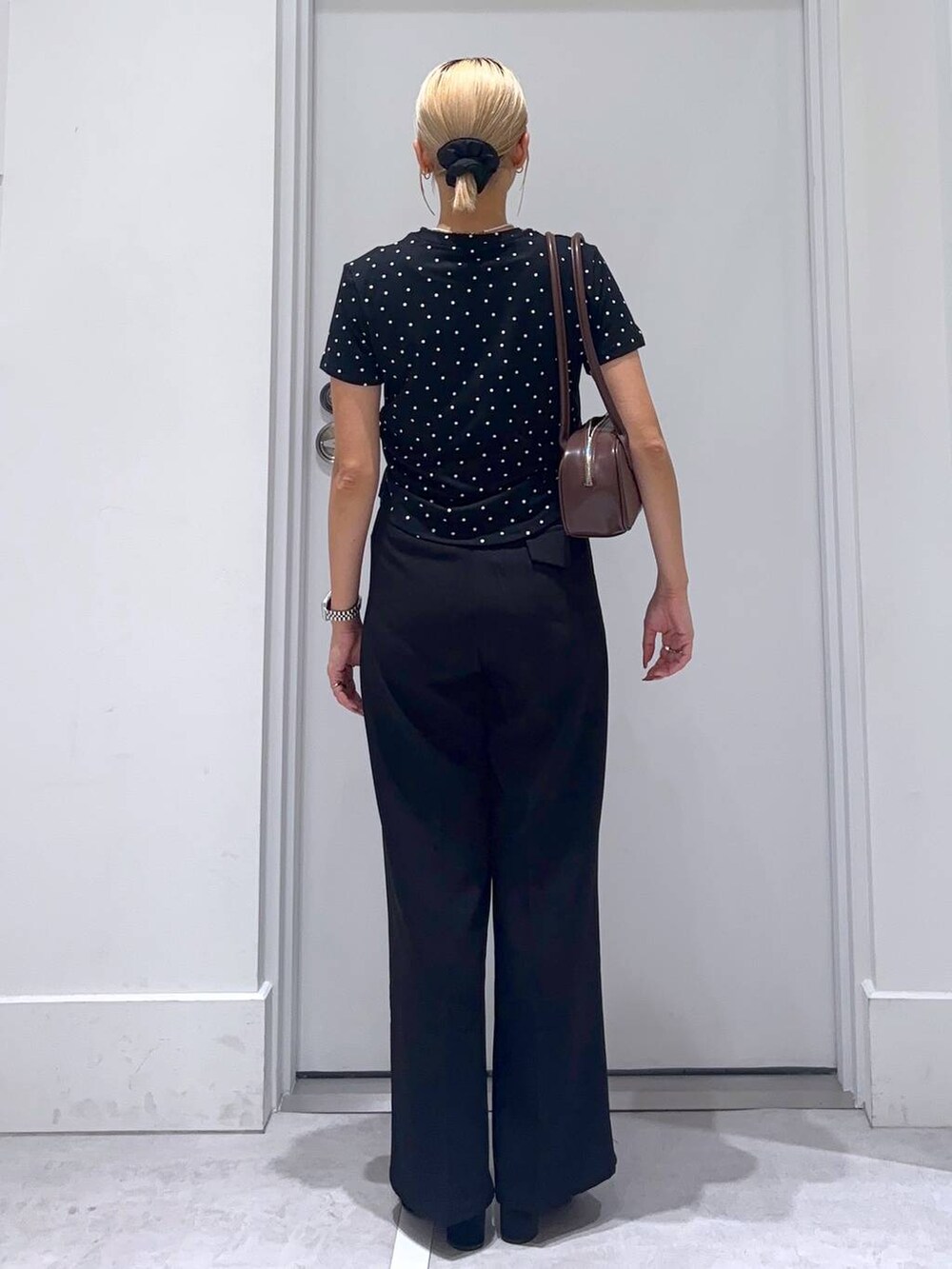 ブラック系のサンダル、ブラウン系のボストンバッグ、ブラック系のスラックスを着用したレディースの秋コーディネートの4枚目の写真