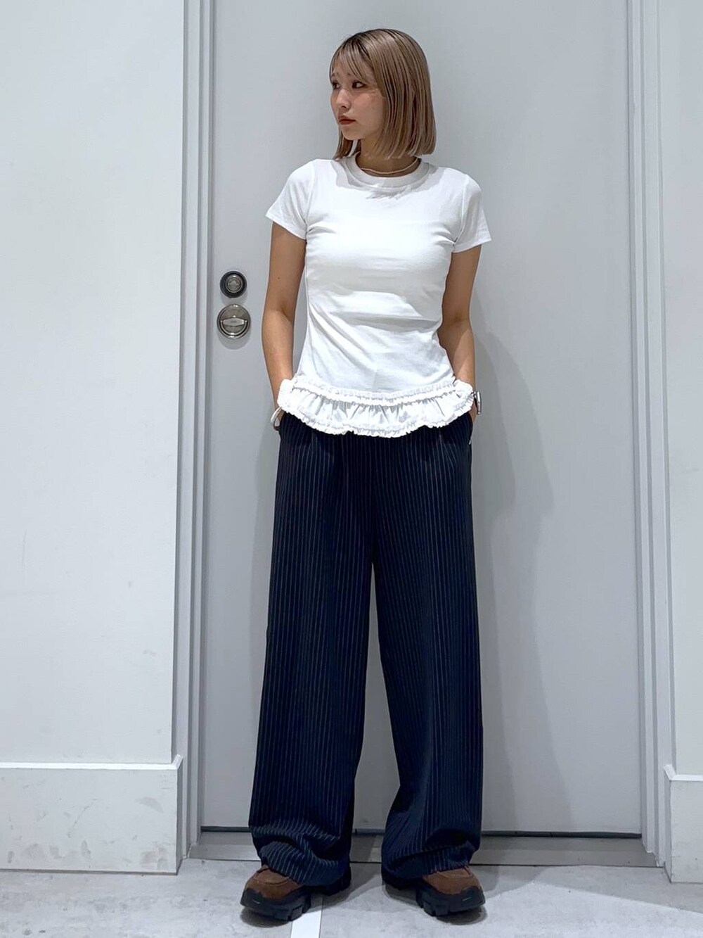ブラウン系のモカシン/デッキシューズ、ブルー系のスラックス、ホワイト系のTシャツ/カットソーを着用したレディースの夏コーディネートの6枚目の写真