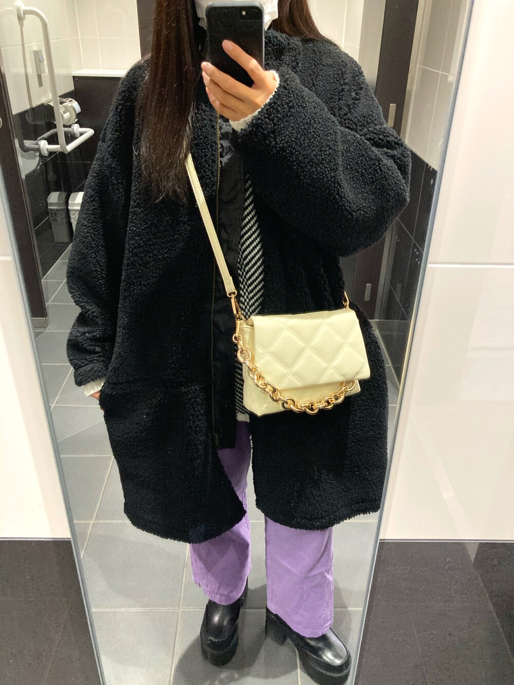 パープル系のその他パンツ、ブラック系のブーツ、ホワイト系のショルダーバッグを着用したレディースの冬コーディネートの2枚目の写真